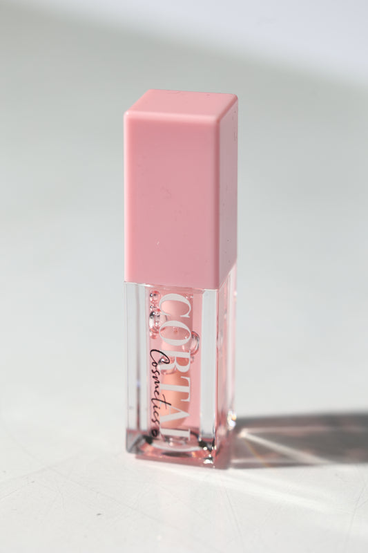 Pink lip gloss with clear cap on a light gray background